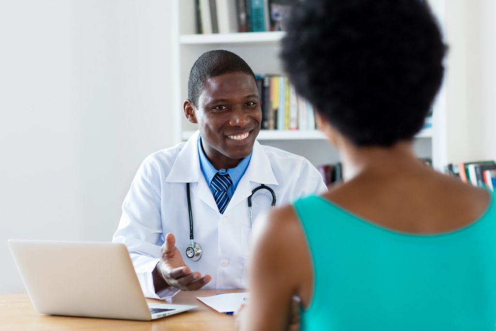 African american doctor with good news for female patient at hospital