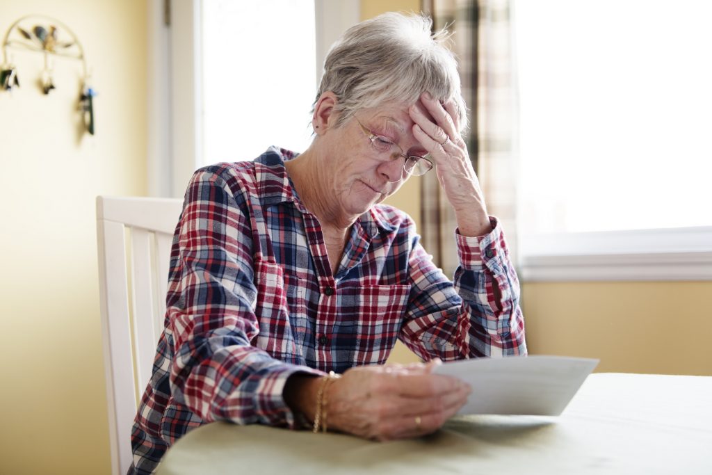 Elderly woman worry about bill notice at home
