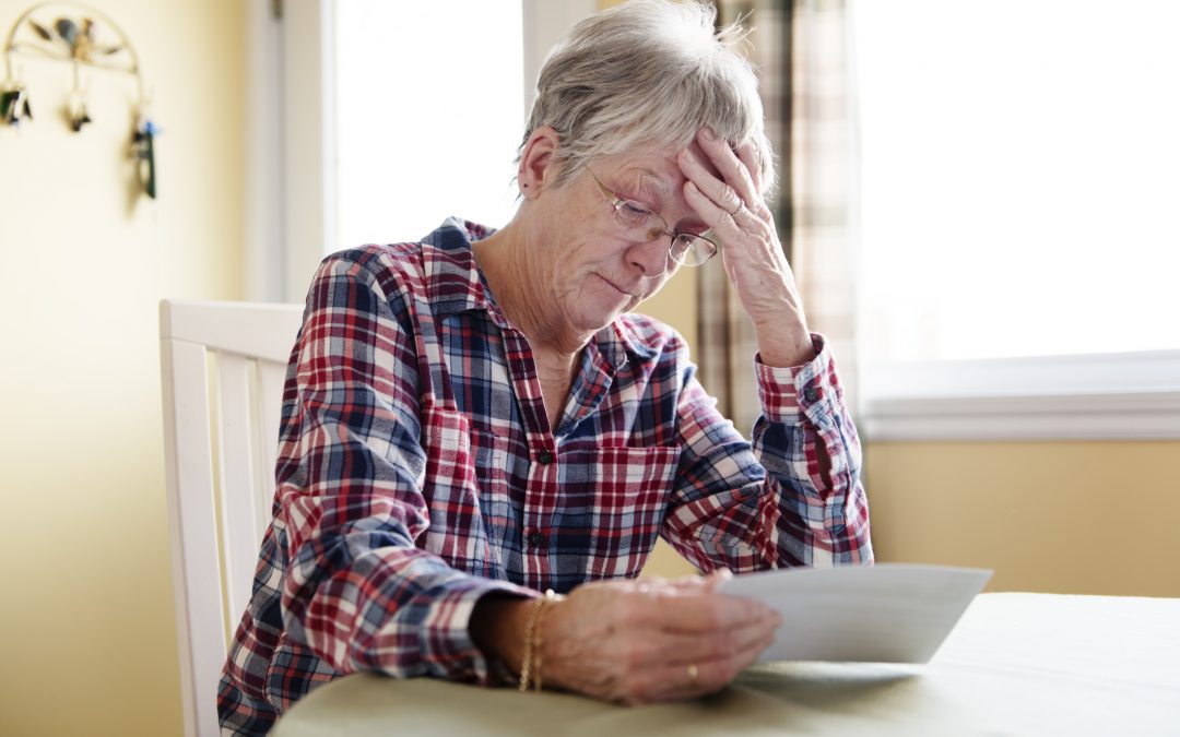 Elderly woman worry about bill notice at home