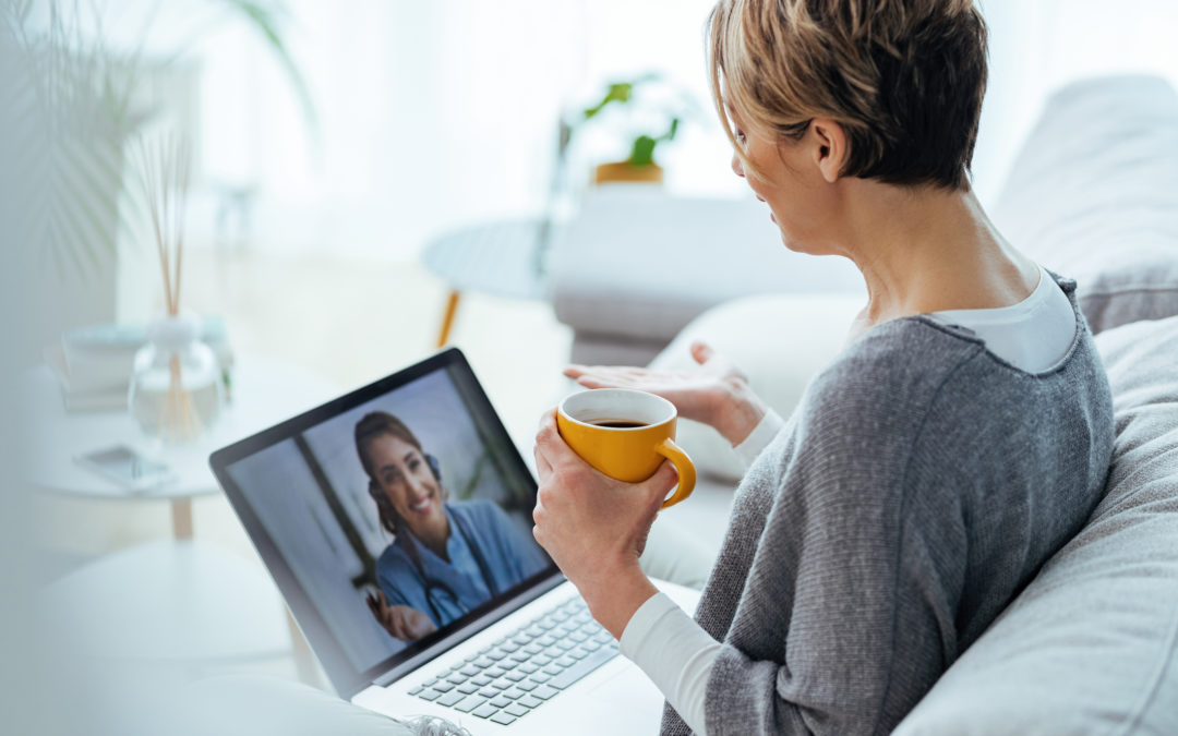 Woman using laptop and having video call with her doctor while sitting at home.